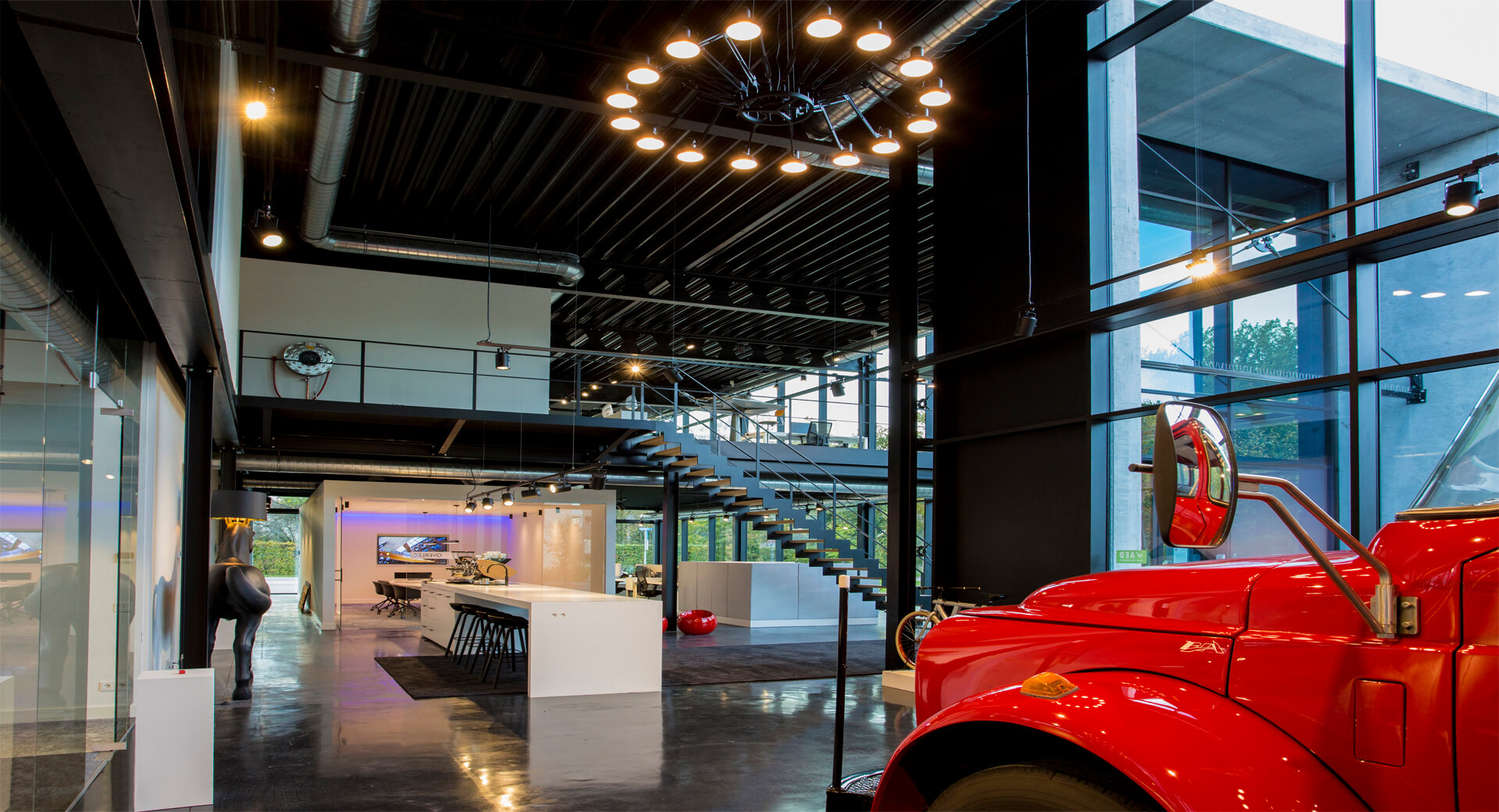 Moderne kantoorruimte met rode vrachtwagen in interieur.