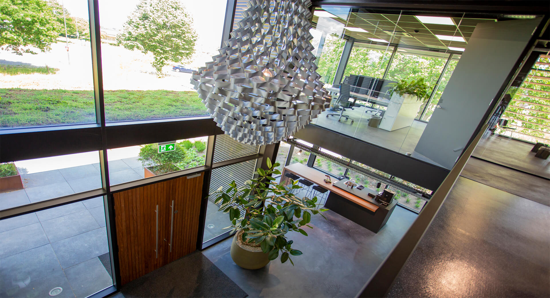 Kantoorinterieur met grote ramen en moderne kroonluchter.