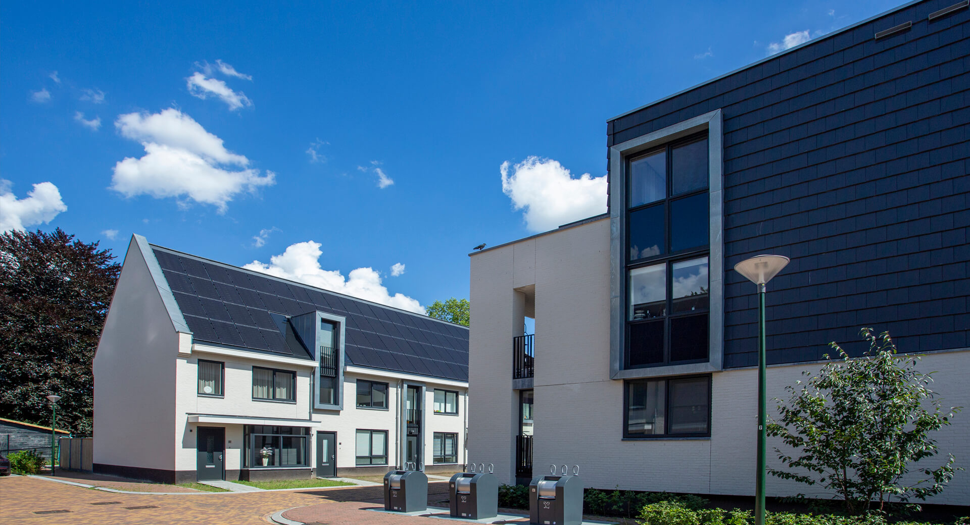 Modern huizenblok met zonnepanelen onder blauwe hemel