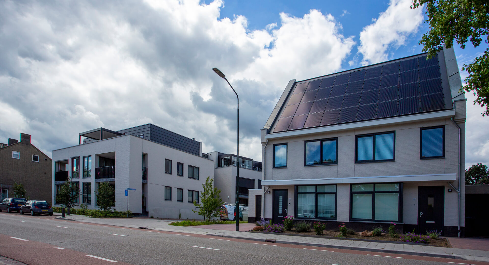 Moderne huizen met zonnepanelen en bewolkte hemel
